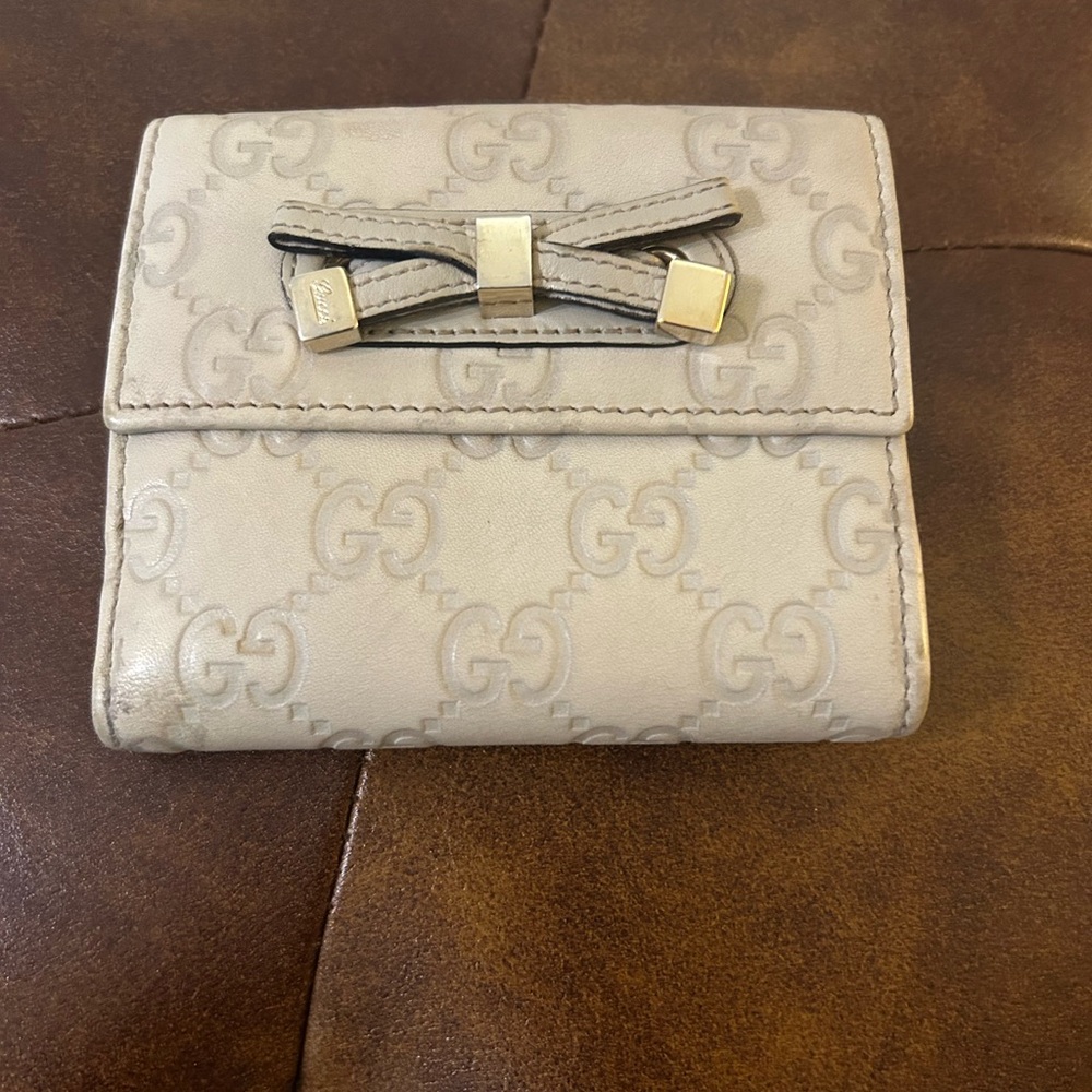 This is a Gucci Guccissima Princy French Flap Wallet in off-white/beige leather.